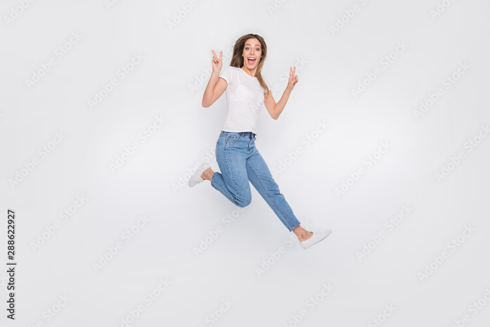 Full length body size photo of nice cute girl running showing you v-sign to say hello while isolated with white background