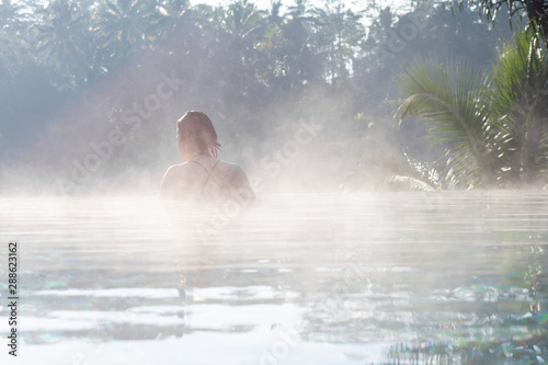 A young woman relaxing in an infinity pool