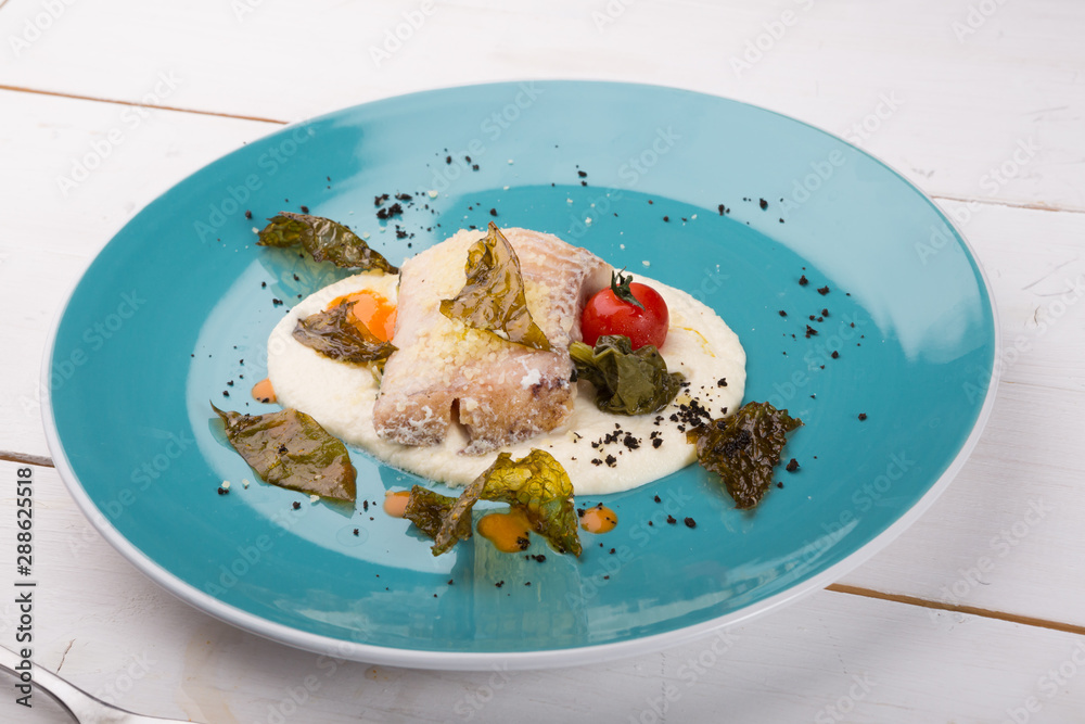 Cooked white fish fillet served with mashed potatoes Cooked white fish fillet served with mashed potatoes