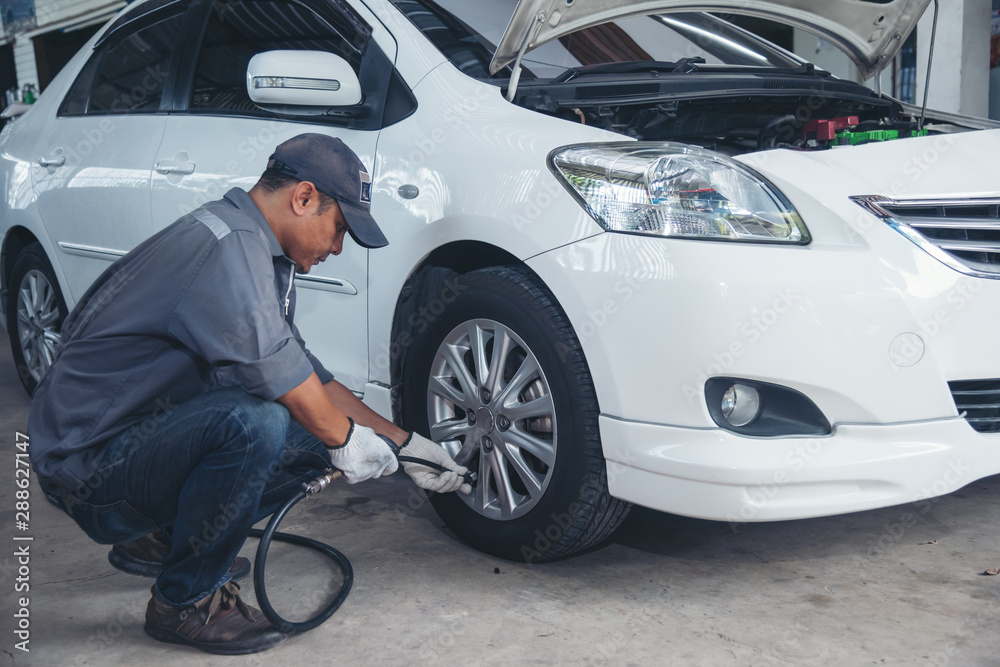motor car mechanic Inflate the tire at garage. motor car mechanic Inflate the tire at garage.