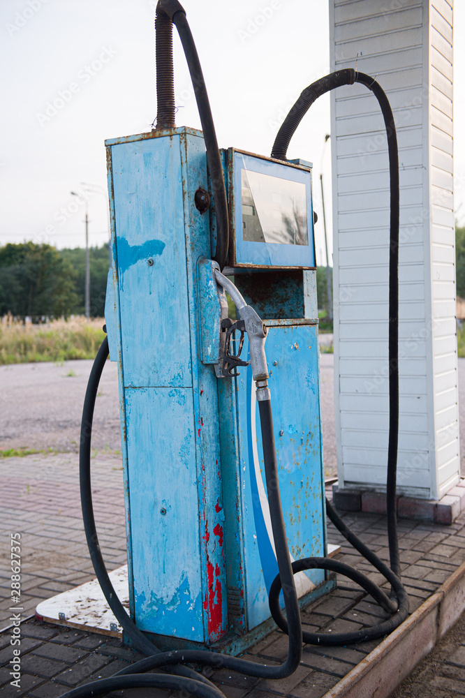 Old abandoned fuel station, gas station on secondary provincial road, fuel dispenser is broken. vintage gasoline column. Oil pollution of the earth. Outdated technology