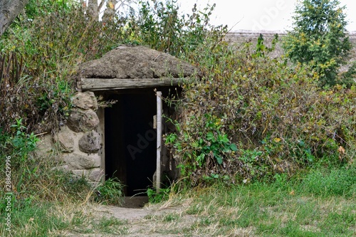 A dugout (or dug-out, pit-house, earth lodge, cellar dug). Traditional shelter for humans and livestock or food storage based on a hole or depression dug into the ground. Poland countryside photo