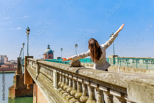 Tourist woman in French ancient town Toulouse and Garonne river. Toulouse is the capital of Haute Garonne department and Occitanie region, France, South Europe. Famous city and tourist destionation.