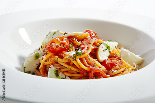 Classical Italian Spaghetti with Milk Mozzarella and Tomato Sauce Top View. Traditional Homemade Pasta, Fresh Basil, Parsley, Garlic, Parmesan, Onion, Cold Smoked Cherry Tomatoes, Chard Isolated