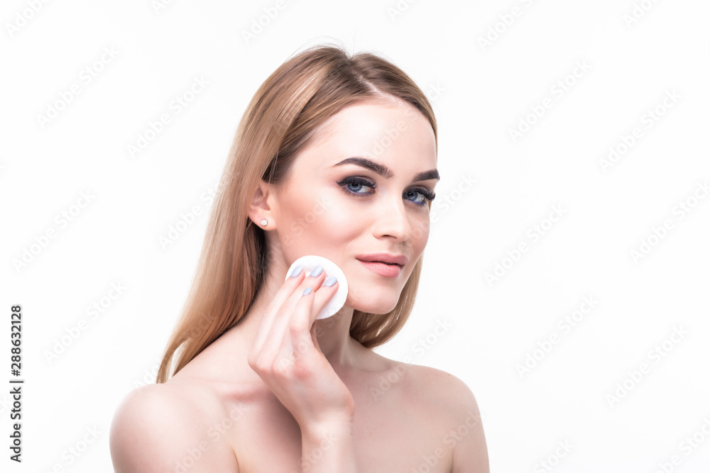 Close-up beauty face of fashion model woman copy space. Blond hair style, perfect skin, apply cosmetics cream with cotton pad. White background. Isolated Close-up beauty face of fashion model woman copy space. Blond hair style, perfect skin, apply cosmetics cream with cotton pad. White background. Isolated