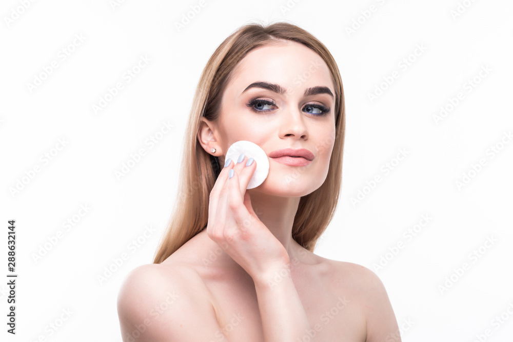 Beautiful young woman applying foundation on face with sponge on white background Beautiful young woman applying foundation on face with sponge on white background