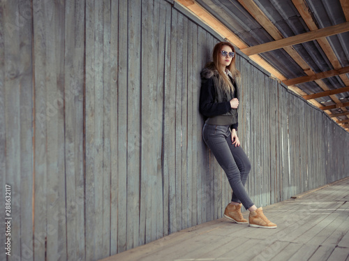 Outdoor lifestyle portrait of pretty young girl, wearing in hipster swag grunge style urban background. Retro vintage toned image, film simulation.