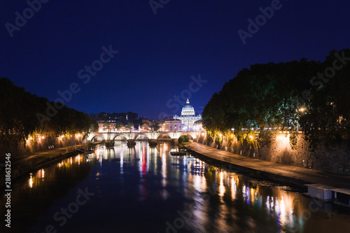 Cityscape romantic night view of Roma. Panorama with Saint Peter s basilica and Saint Angelo castle and bridge. Famous tourist destination with Tiber. Travel illuminated landscape in Italy  Europe.
