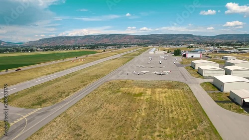 An eagle view of Heber City airport with runway planes and hangars. Aerial shot of Heber Valley mountains with an airport. Highway, biplanes, monoplanes, ramps and hangars.
