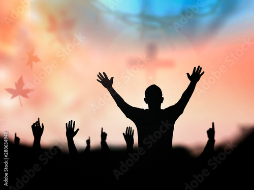 Praise and worship concept: Silhouette human looking for the cross on autumn sunrise background