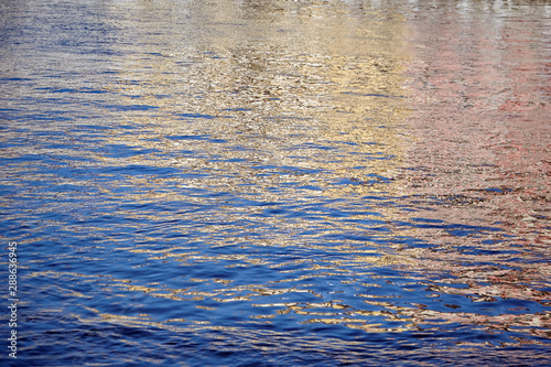 Colorful ripples on the water surface. Reflections in the river