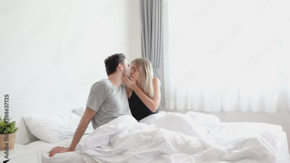 Young couple kissing in the bed .loving couple in bedroom Young couple kissing in the bed .loving couple in bedroom