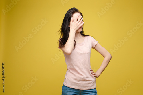 Waist up portrait of surprised beautiful girl with nice long hair, perfect makeup and fashion manicure. She is looking at camera with astonishment. Isolated on dark background