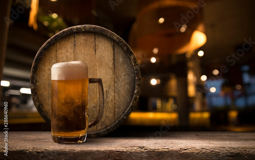 Beer brewing ingredients Hop in bag and wheat ears on wooden cracked old table. Beer brewery concept. Hop cones and wheat closeup. Sack of hops and sheaf of wheat on vintage background. photo