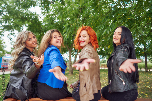 group of young cheerful women are relaxing in the park