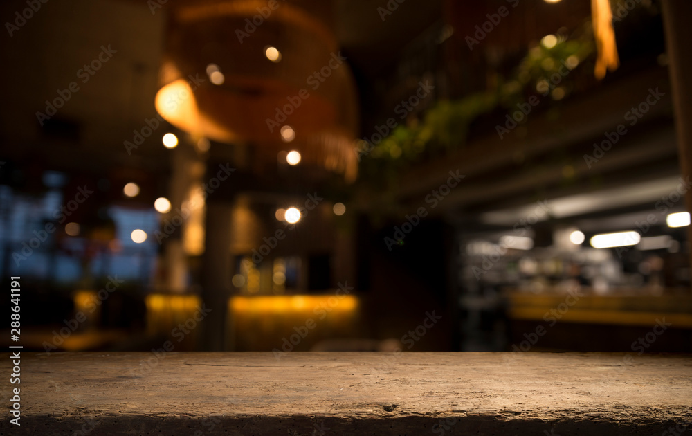 Empty wood table top on blur light gold bokeh of cafe restaurant in dark background