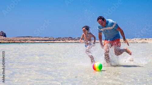 padre e figlio giocano sulla spiaggia di Balos a creta, Grecia photo