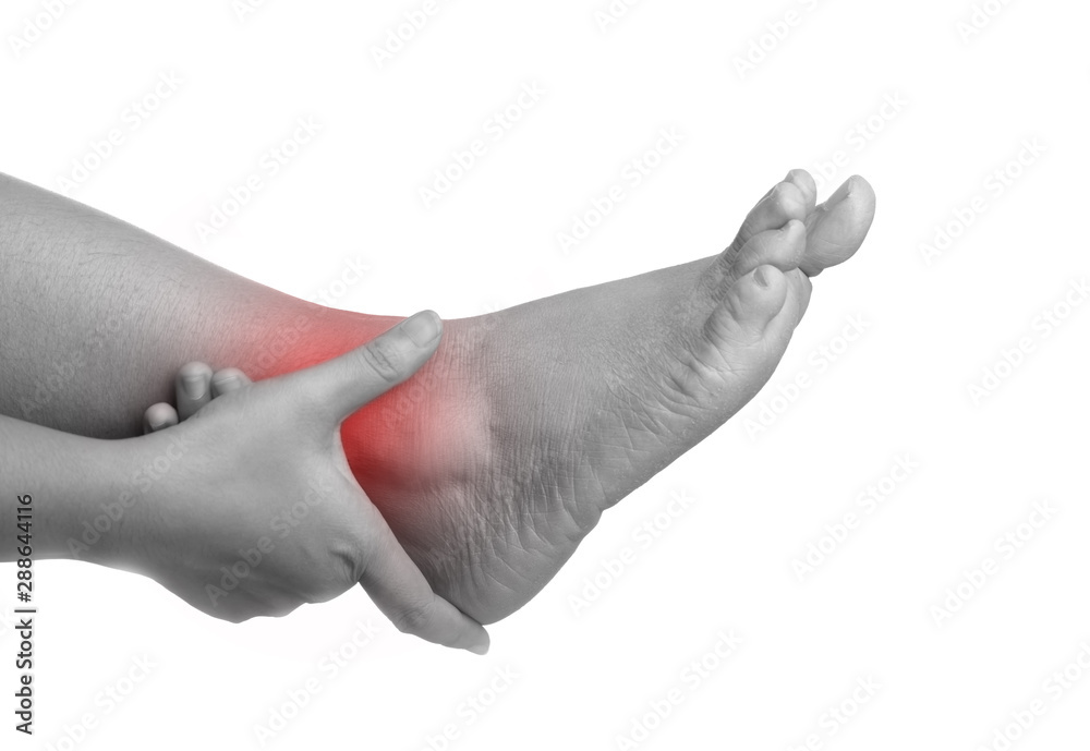 Woman with ankle pain using hand holding leg and massaging painful her Woman with ankle pain using hand holding leg and massaging painful her