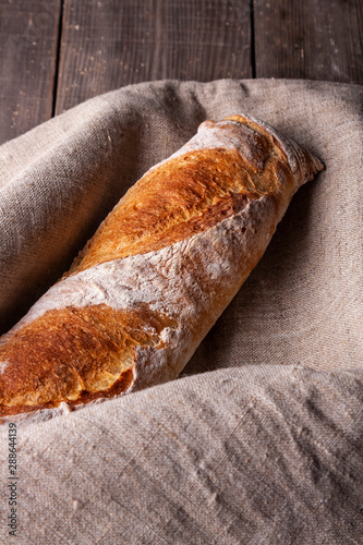 Hot french bagette on roustic wrap in boulangerie. Bred, food, closeup photo