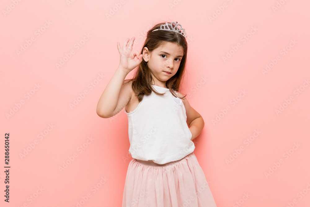 Little girl wearing a princess look cheerful and confident showing ok gesture.