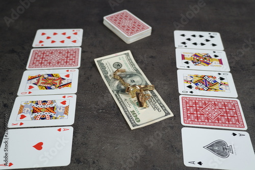 The combination of Flash Royal cards on a gray table with money and gold. Close-up. Poker game