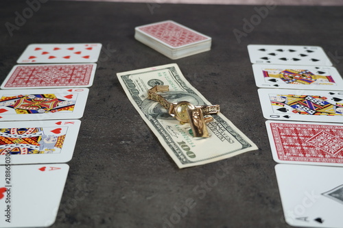 The combination of Flash Royal cards on a gray table with money and gold. Close-up. Poker game