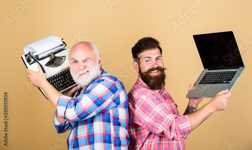 Modern life and remnants of past. Digital technologies. Battle of technologies. Old generation. Senior man with typewriter and hipster with laptop. Master new technologies. Men work writing devices photo