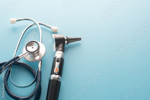 Otoscope with stethoscope on blue background. photo