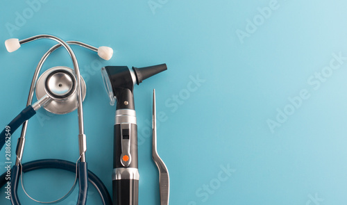 Otoscope with stethoscope on blue background. photo