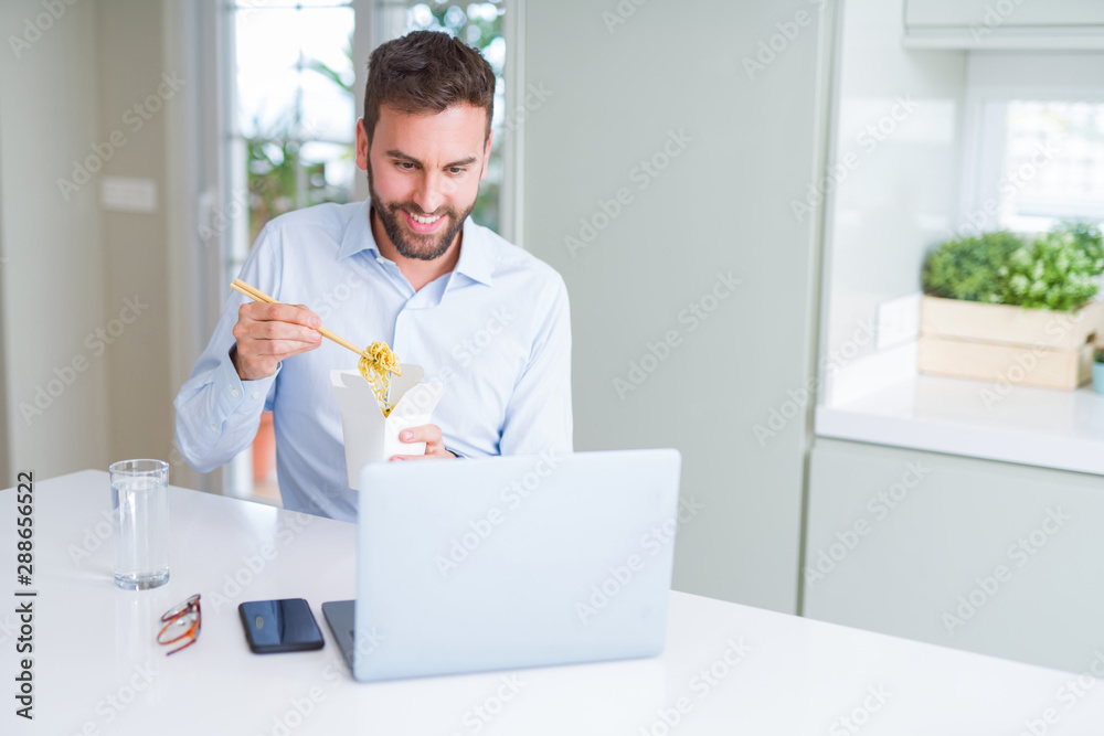 Fényképezés Business man eating take away asian noodles food while working using computer la