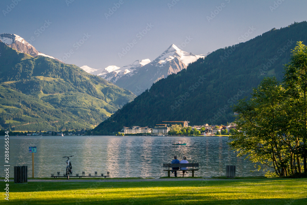 two people relax on a bench on Lake Zell am See