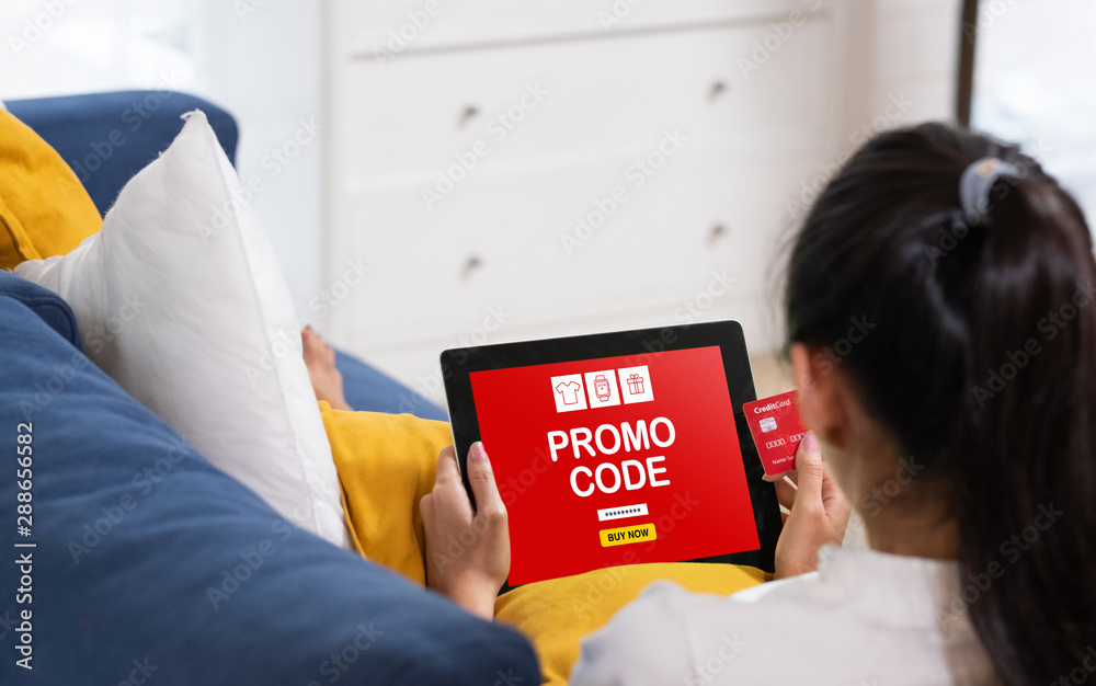 Φωτογραφία Asian woman online shopping with credit card and tablet sitting on sofa at home