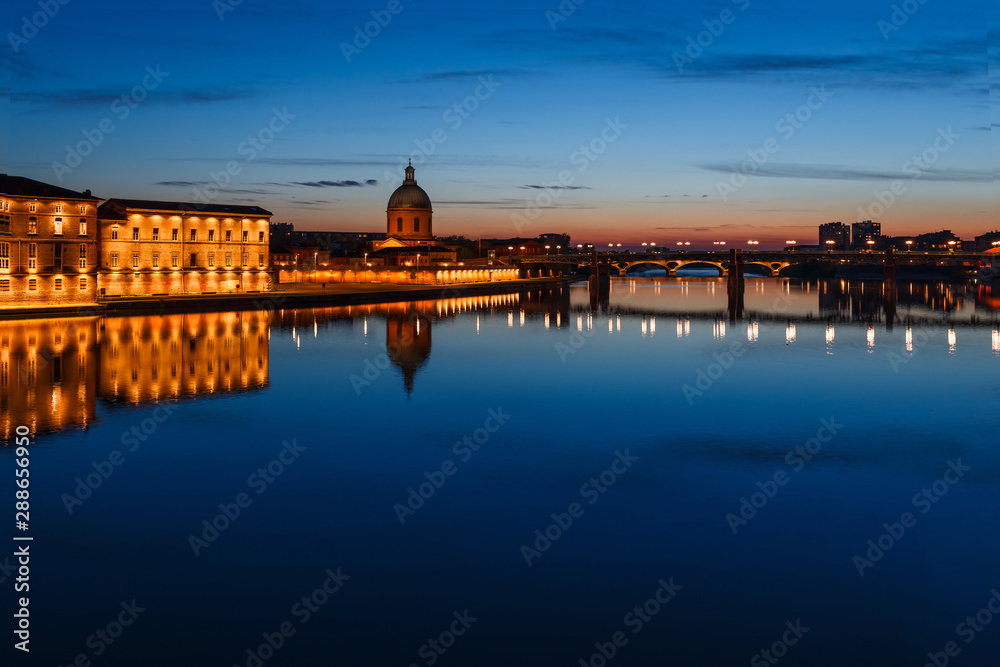French ancient town Toulouse and Garonne river panoramic night view. Toulouse is the capital of Haute Garonne department and Occitanie region, France, South Europe. Famous tourist destionation.