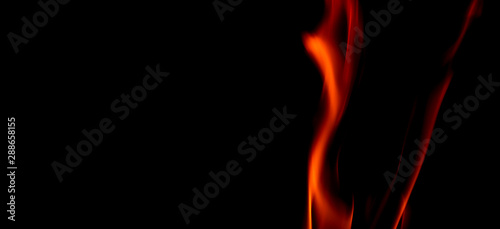 Fire texture isolated on black background. Fire flames on black background. Fire patterns. Texture of flames throughout the space. Red flames up close. The background with flames of fire..