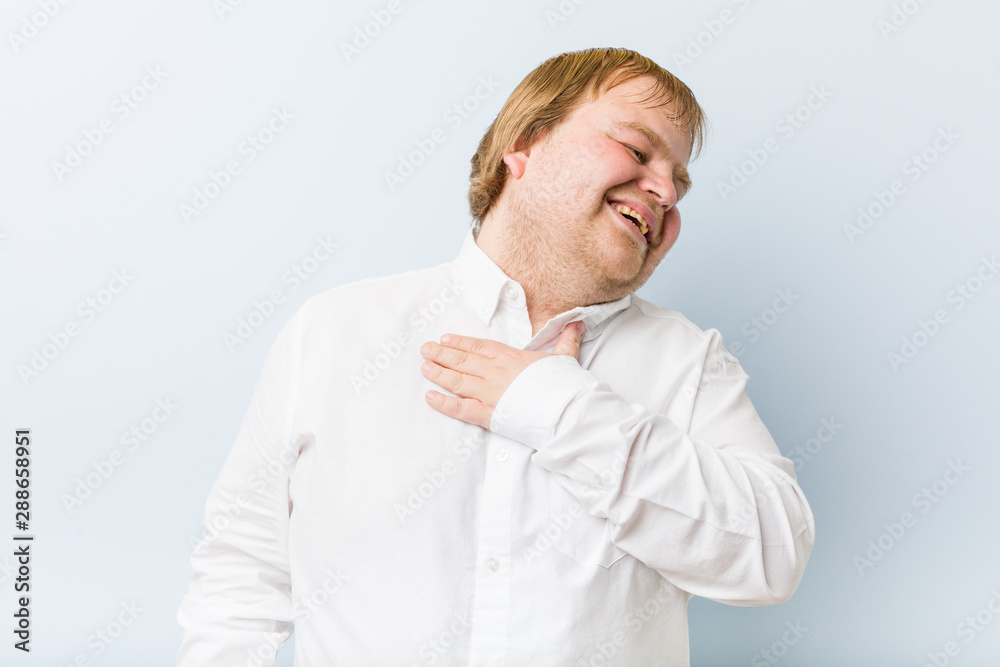 Young authentic redhead fat man laughs out loudly keeping hand on chest. Young authentic redhead fat man laughs out loudly keeping hand on chest.