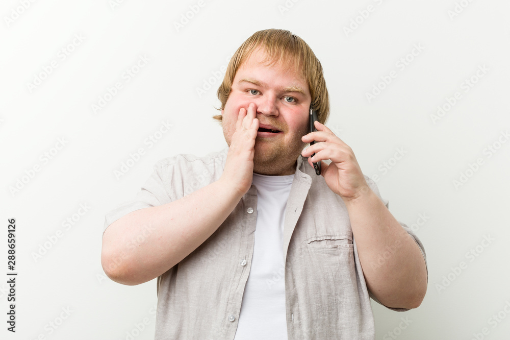 Caucasian plus size man calling by phone shouting excited to front. Caucasian plus size man calling by phone shouting excited to front.