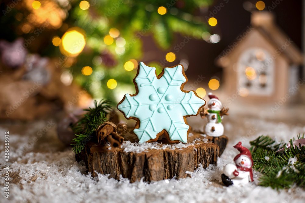 Holiday traditional food bakery. Gingerbread blue snowflake in cozy warm decoration with garland lights