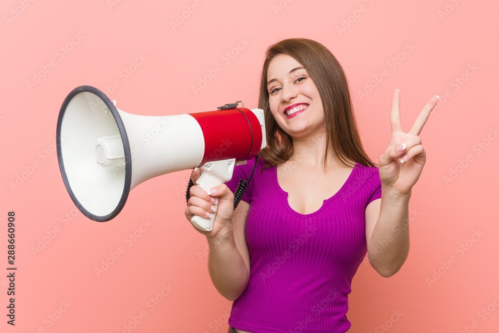 Young caucasian woman speaking through a megaphone Young caucasian woman speaking through a megaphone