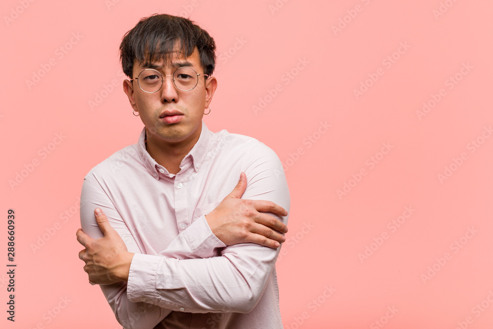 Young chinese man going cold due to low temperature Young chinese man going cold due to low temperature