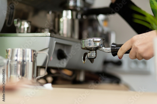 Barista girl is preparing aromatic coffee with a coffee machine. Barista work in a coffee shop