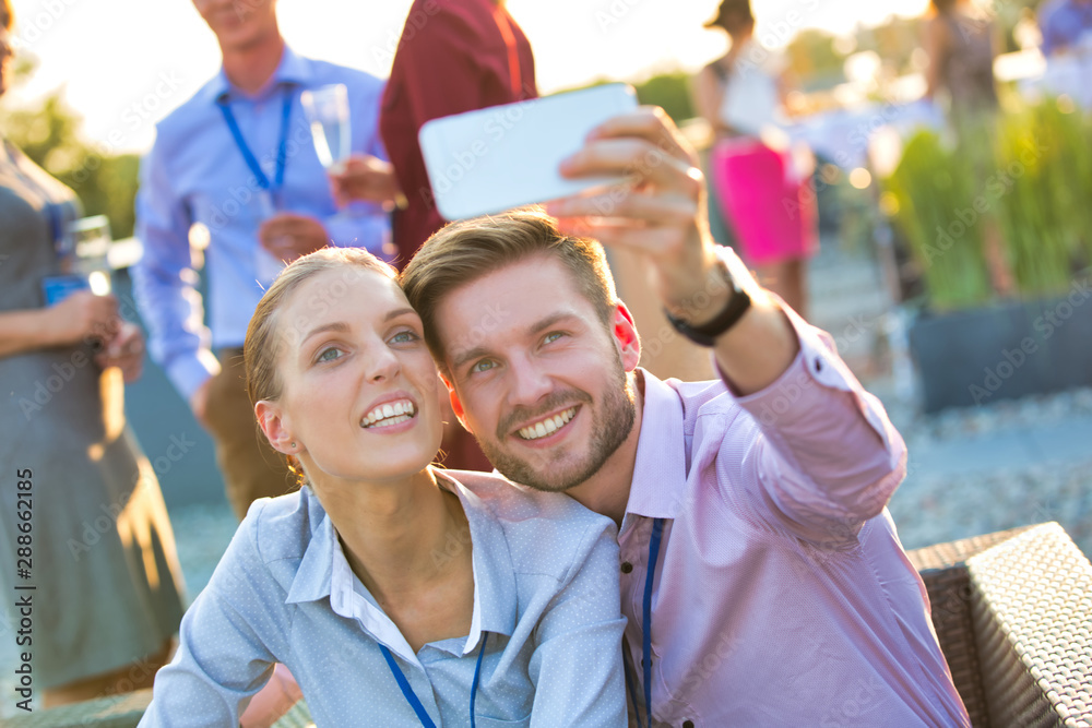 Obraz premium Businessman taking selfie with colleague during rooftop party