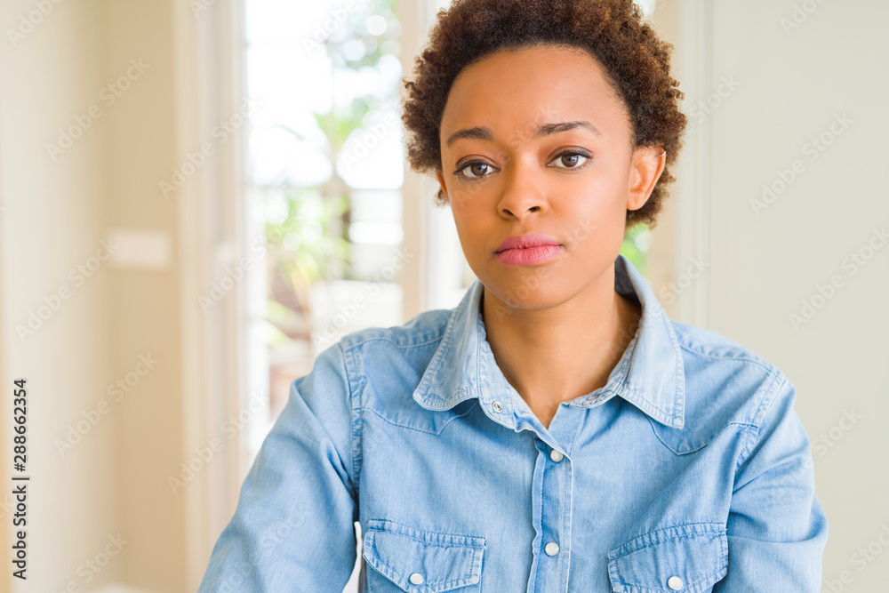 Young beautiful african american woman with serious expression on face. Simple and natural looking at the camera. Young beautiful african american woman with serious expression on face. Simple and natural looking at the camera.