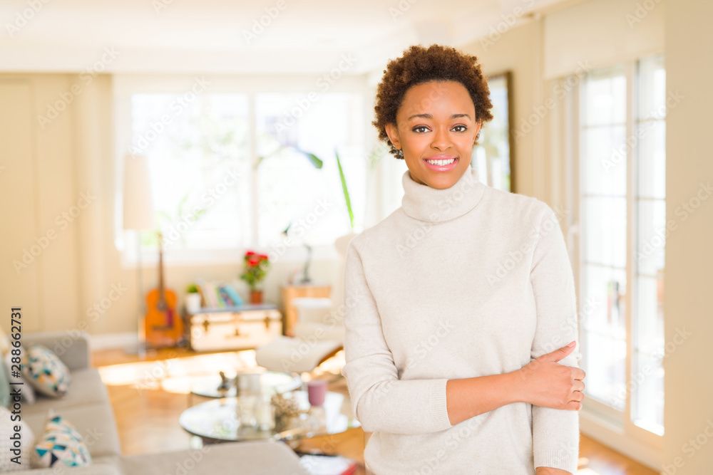 Beautiful young african american woman smiling confident to the camera showing teeth with crossed arms Beautiful young african american woman smiling confident to the camera showing teeth with crossed arms