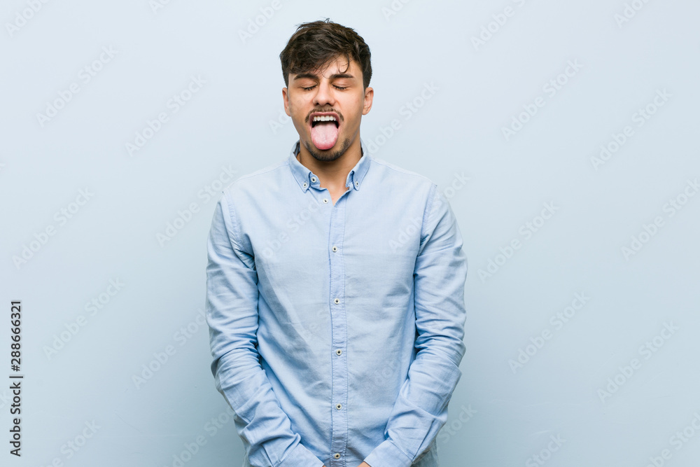 Fototapeta premium Young hispanic business man funny and friendly sticking out tongue.