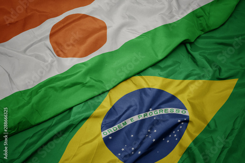 waving colorful flag of brazil and national flag of niger. photo