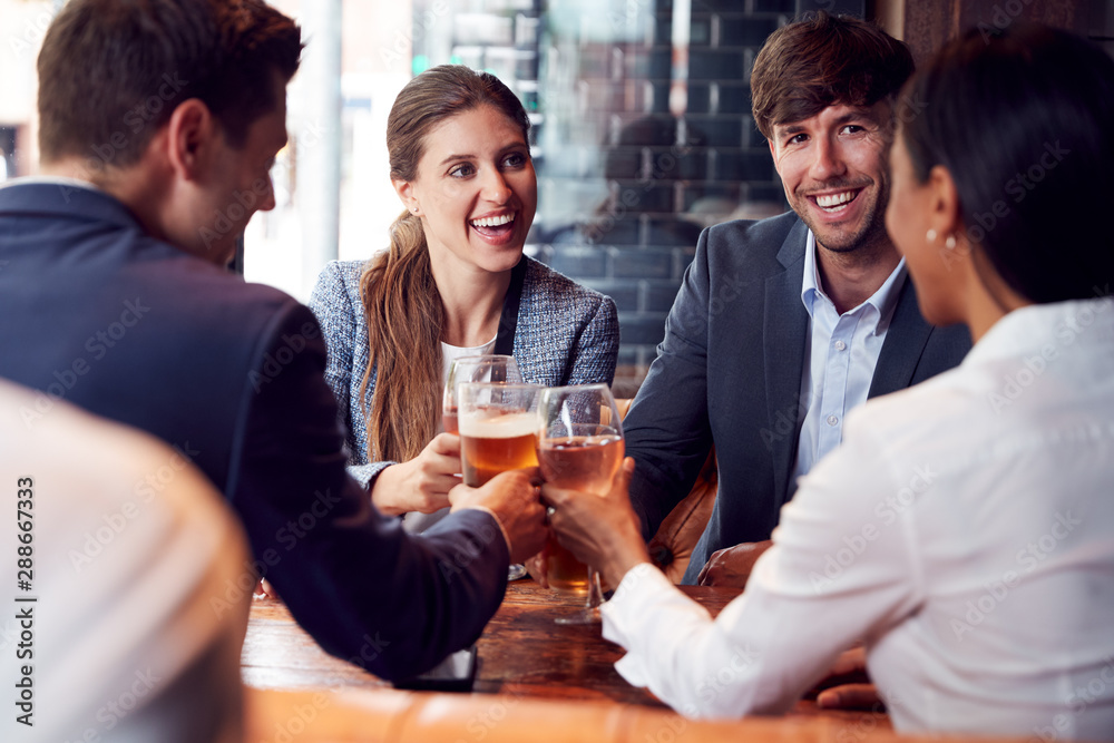 Group Of Business Colleagues Making A Toast As They Meet For Drinks And Socialize In Bar After Work Group Of Business Colleagues Making A Toast As They Meet For Drinks And Socialize In Bar After Work