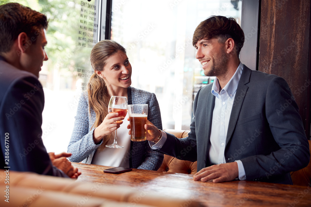 Group Of Business Colleagues Making A Toast As They Meet For Drinks And Socialize In Bar After Work