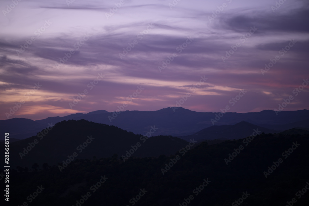 Pink clouded sky with mountains