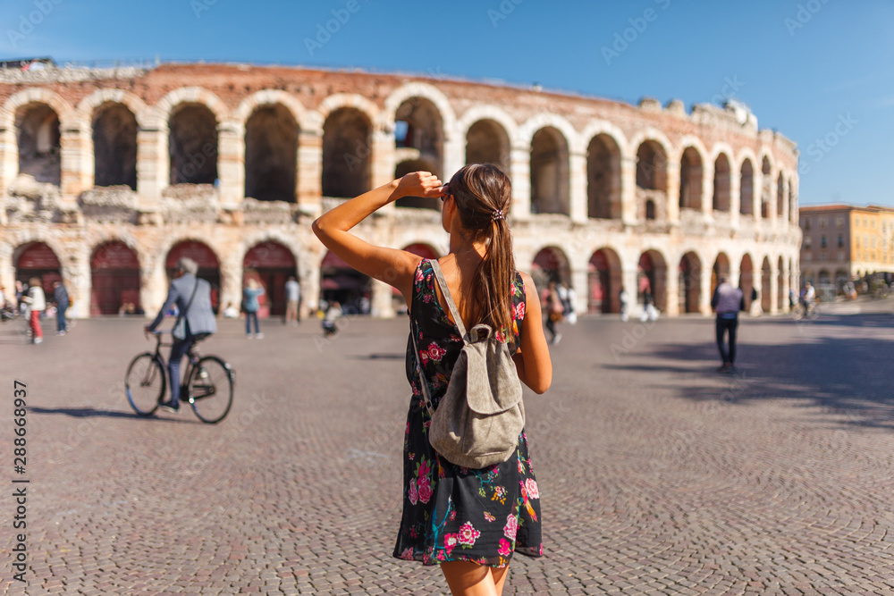 Toirust woman in Verona historical center on square near Arena Verona, Roman amphitheater. Traveler in famous travel destination in Italy. Old town where lived Romeo and Juliet from Shakespeare story