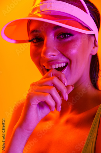 Image closeup of glamour sexy woman wearing sun visor cap and sportswear posing at camera